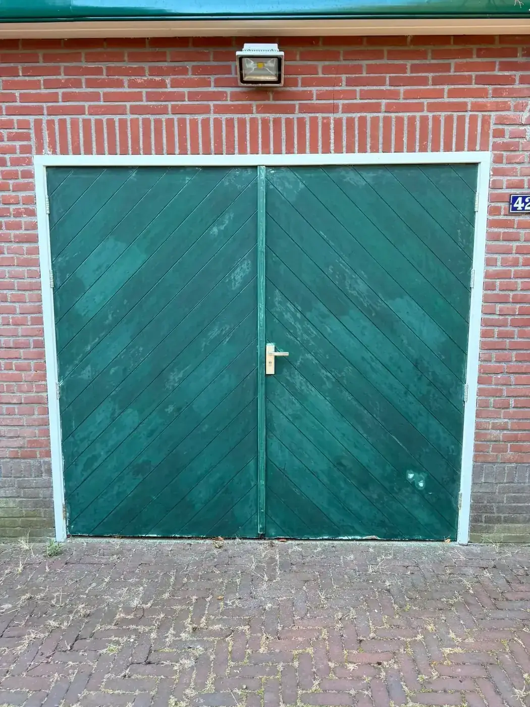 Garagedeuren voor het schilderen, vervaagde verf en verweerd hout